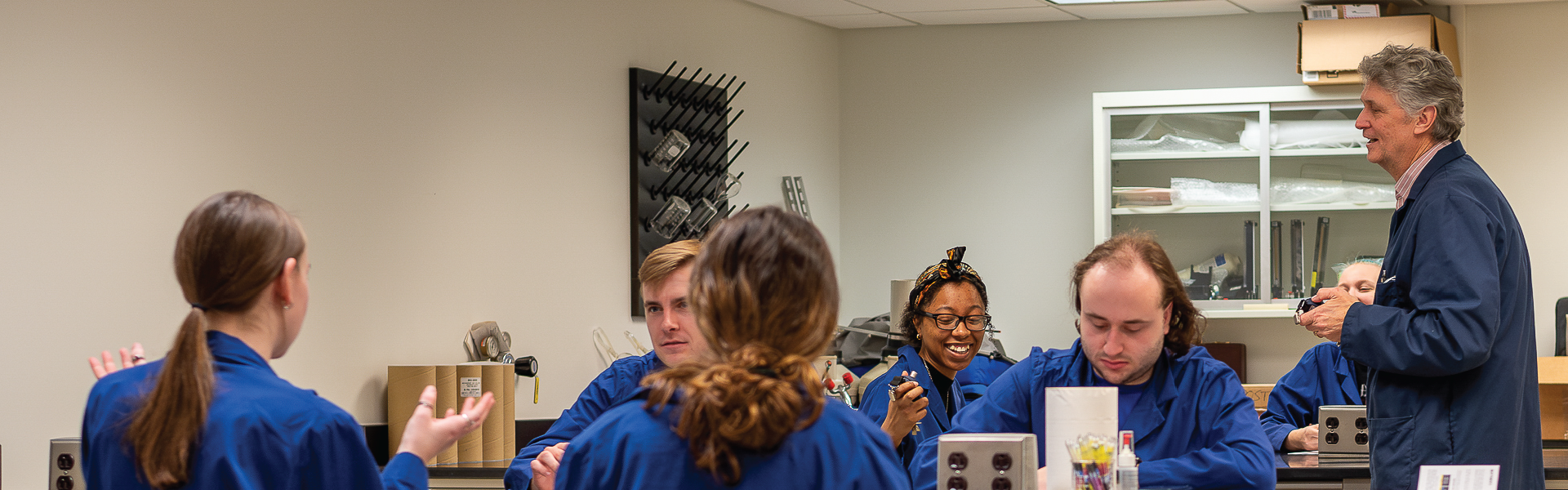 Environmental Systems Engineering students smiling in lab classroom watching demonstration.