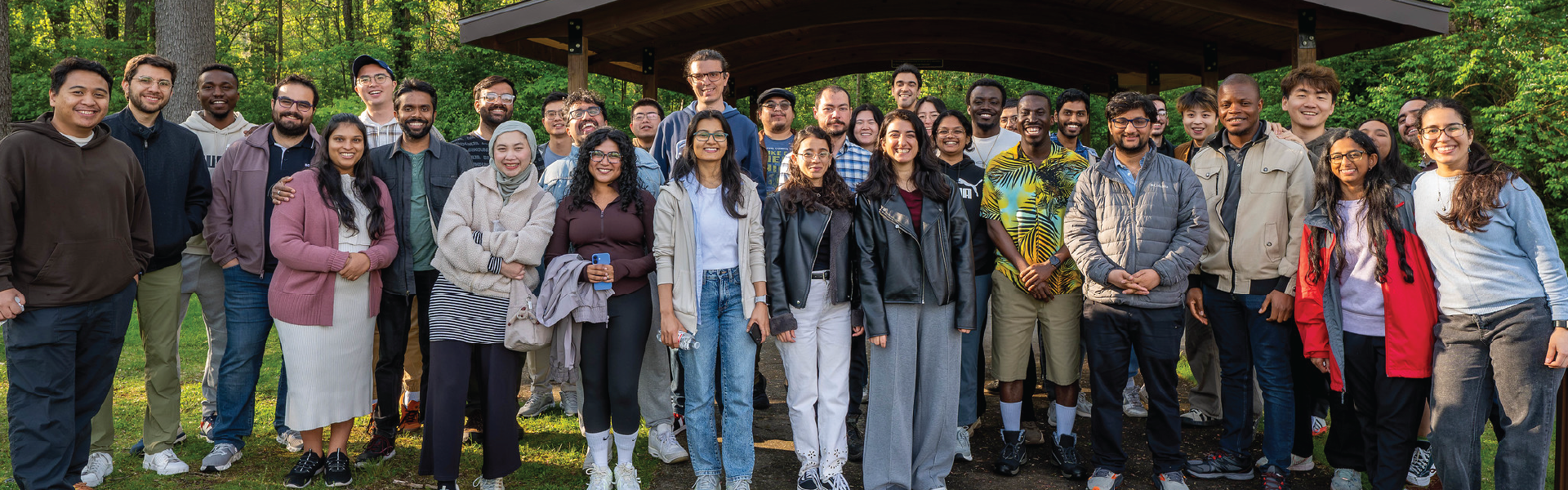 Group photo of diverse graduate students outside in woods.