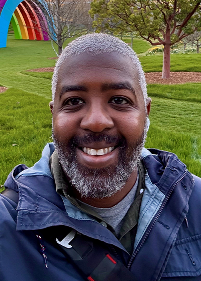 Liston Jackson smiling outside in front of green lawn.