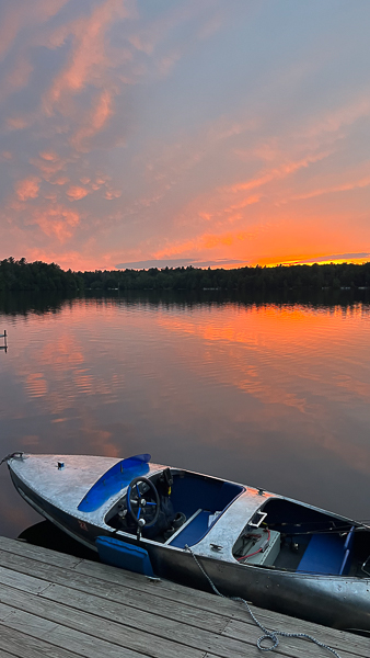 boat tied to dock at sunset