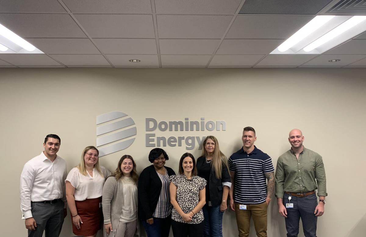 Group smiling in front of Dominion Energy