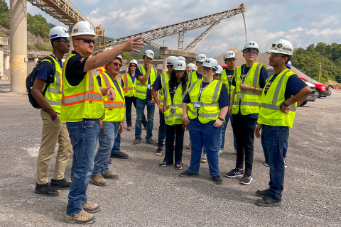 Student group in neon safety vests and hard hats at quarry.