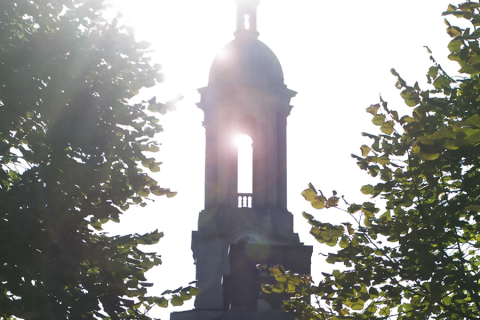 Old Main silhouette with sun flare