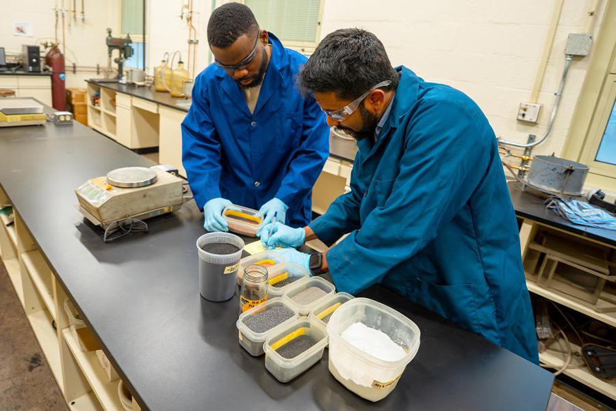 Chandima Hevapathiranage wearing blue lab coat in lab.