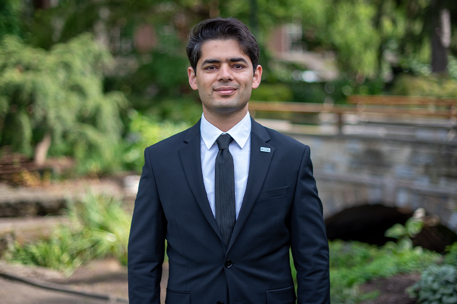 Younes Shekarian outside in Hintz Alumni Garden smiling