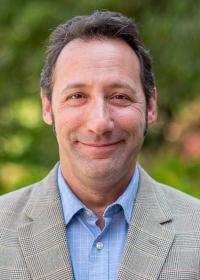 Seth Blumsack outside in blue shirt and patterned suit. 